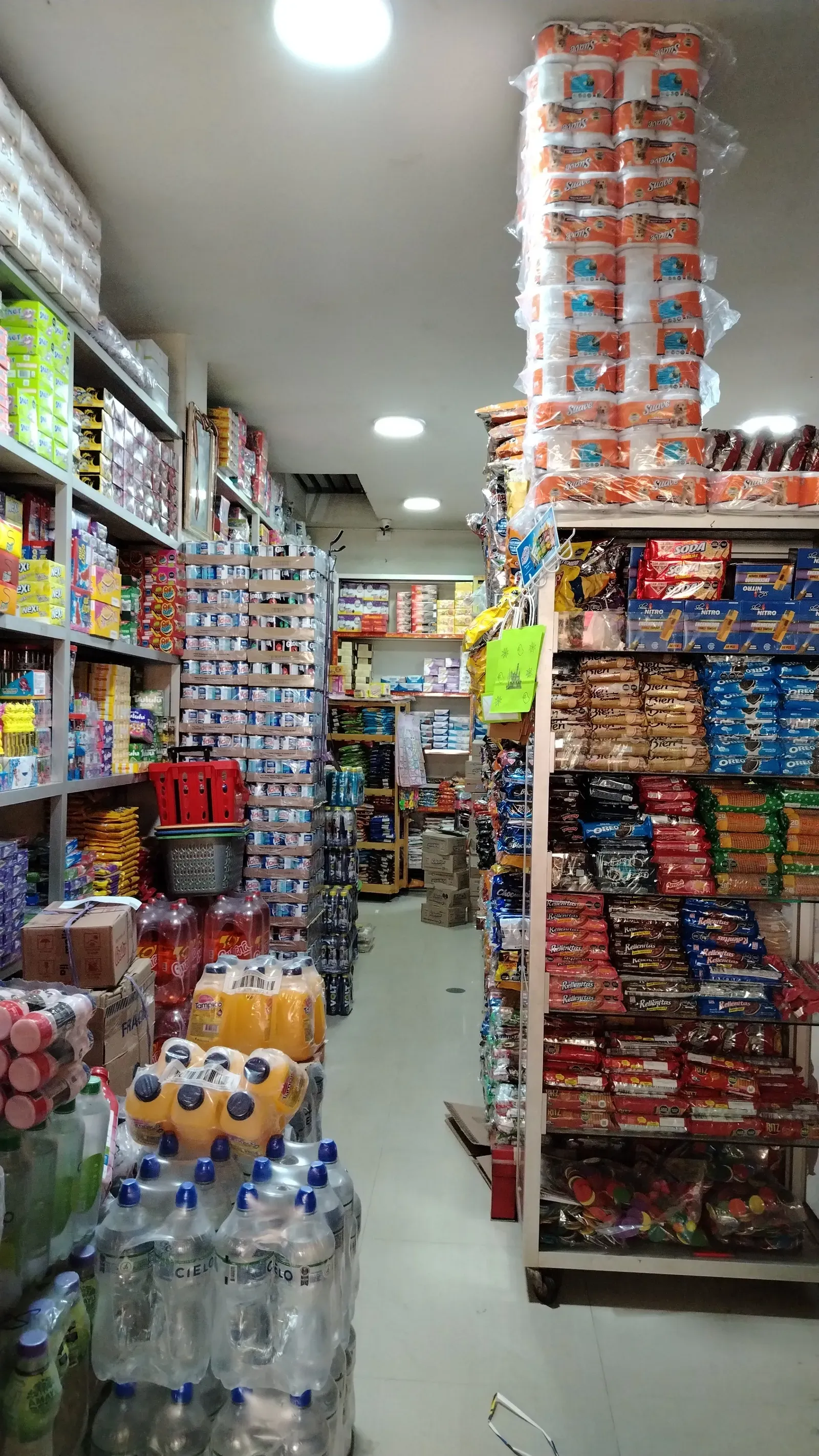 Pasillo interior con abarrotes, papel higiénico, galletas y bebidas